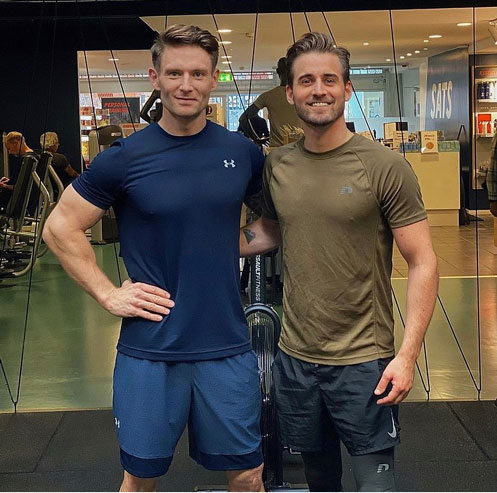 Kenneth standing next to client in the gym